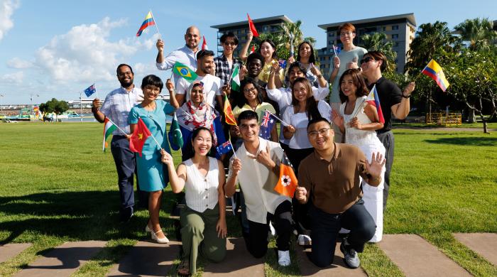 A group of international students from different countries waiving with their country flags